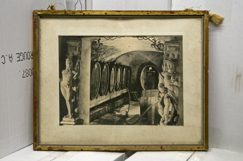 Museum: Historische Schwarz-Wei&szlig;-Aufnahme eines Weinkellers mit Holzf&auml;ssern, verziert mit klassischen Skulpturen und Rundb&ouml;gen.