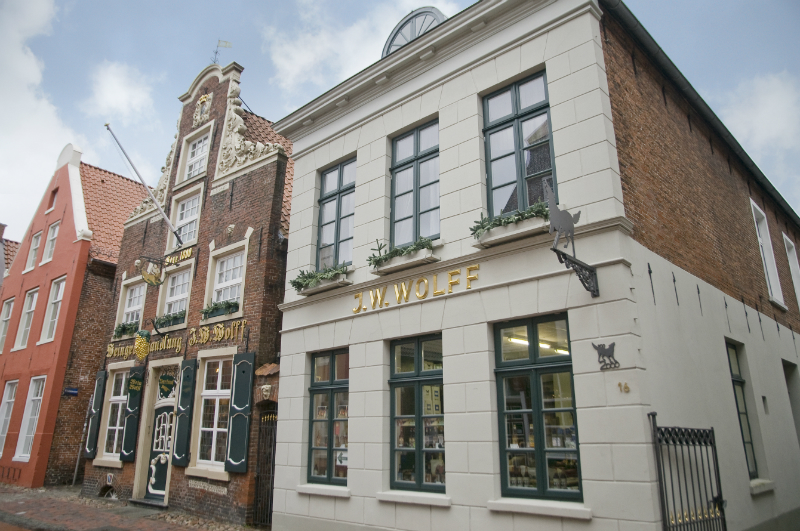 Fassade des historischen Geb&auml;udes J.W. Wolff mit traditioneller Backsteinarchitektur und wei&szlig;em Anbau.