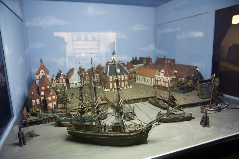 Museum: Modell eines historischen Hafens mit Segelschiffen, umgeben von Giebelh&auml;usern und einer Stadtansicht.
